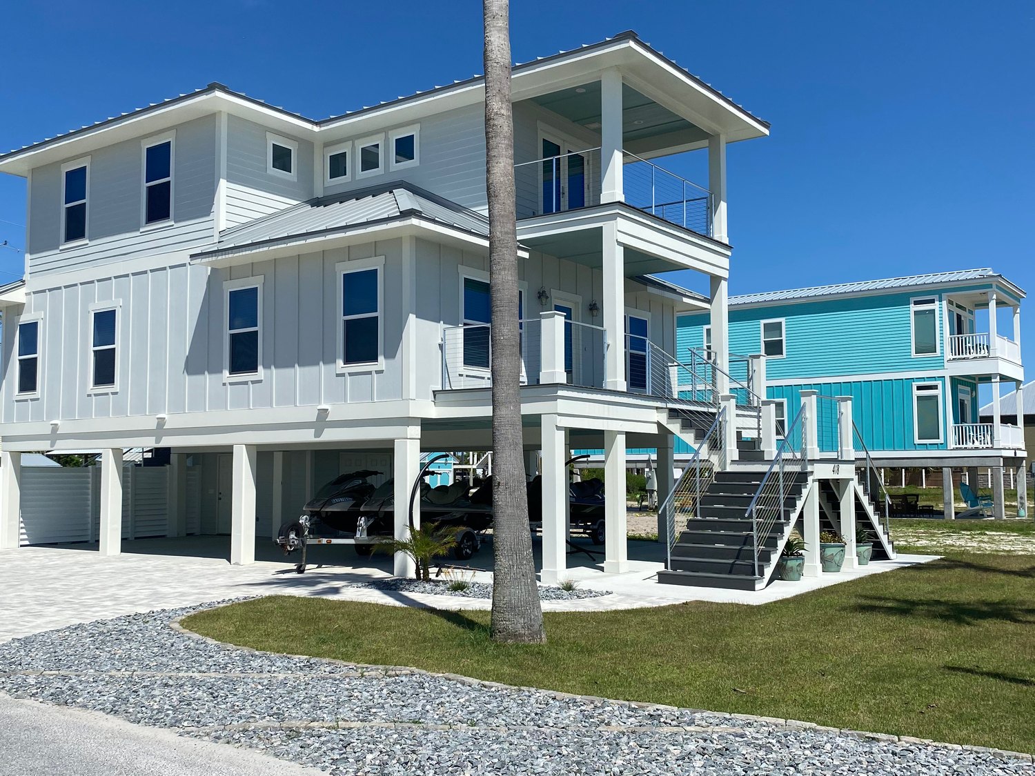 Completed raised coastal residence with covered outdoor living and metal railings